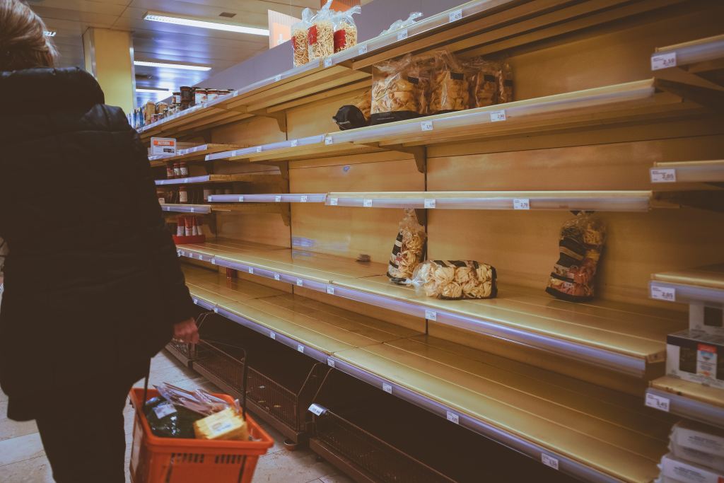 a caregiver next to empty grocery store shelves, demonstrating the importance of being prepared for emergencies.