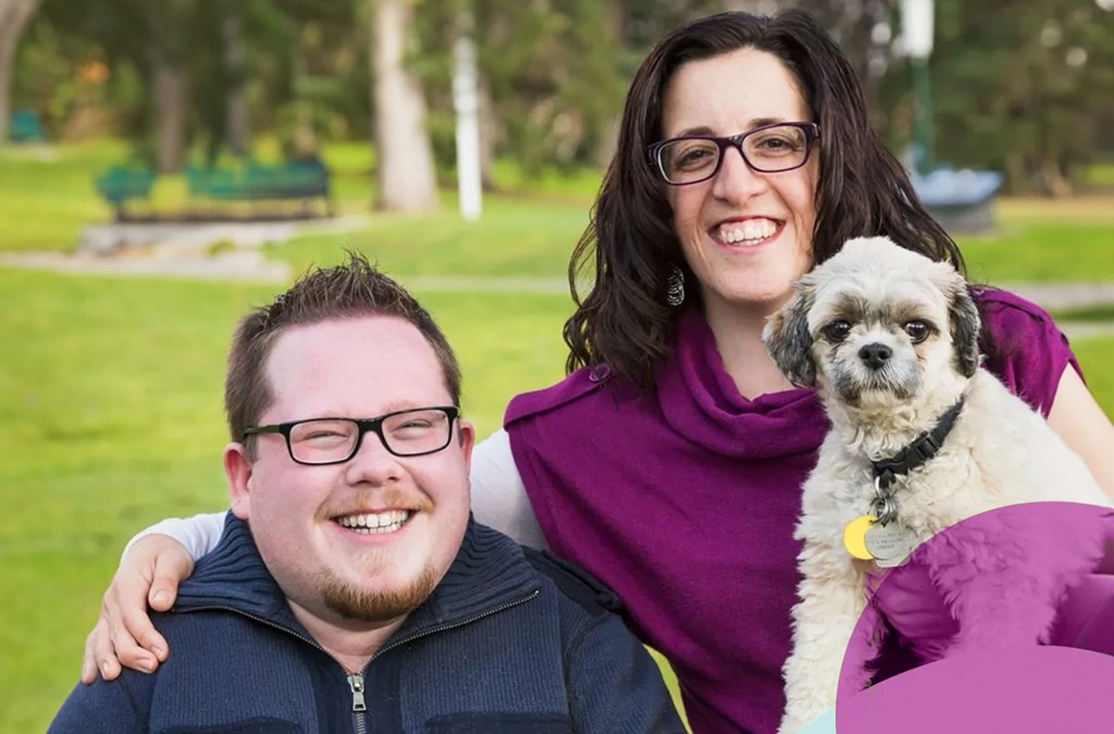 Caregivers share smiles outside with their beloved dog