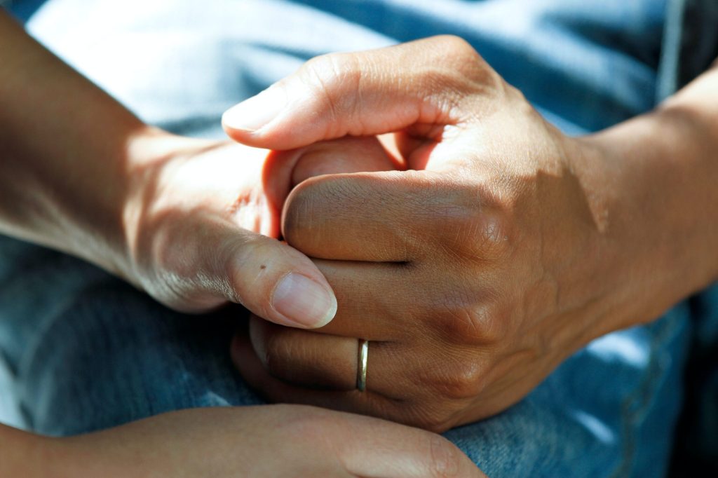 A caregiver's gentle hands offering support and comfort through a warm embrace
