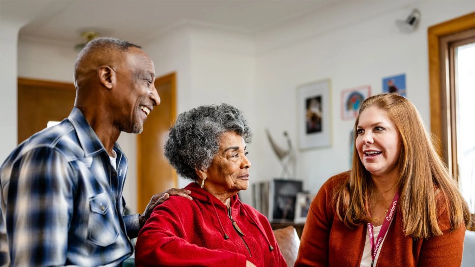 Family caregiver and his wife talking with their Careforth care coach at home, discussing caregiving support and resources.