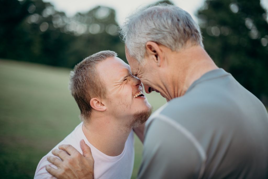 A caregiver father sharing a joyful moment with his son