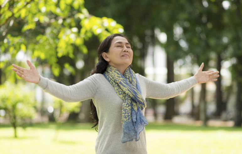 A caregiver spreading her arms out as she embraces the spring air