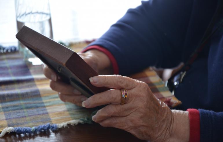 An elderly lady holding a picture frame