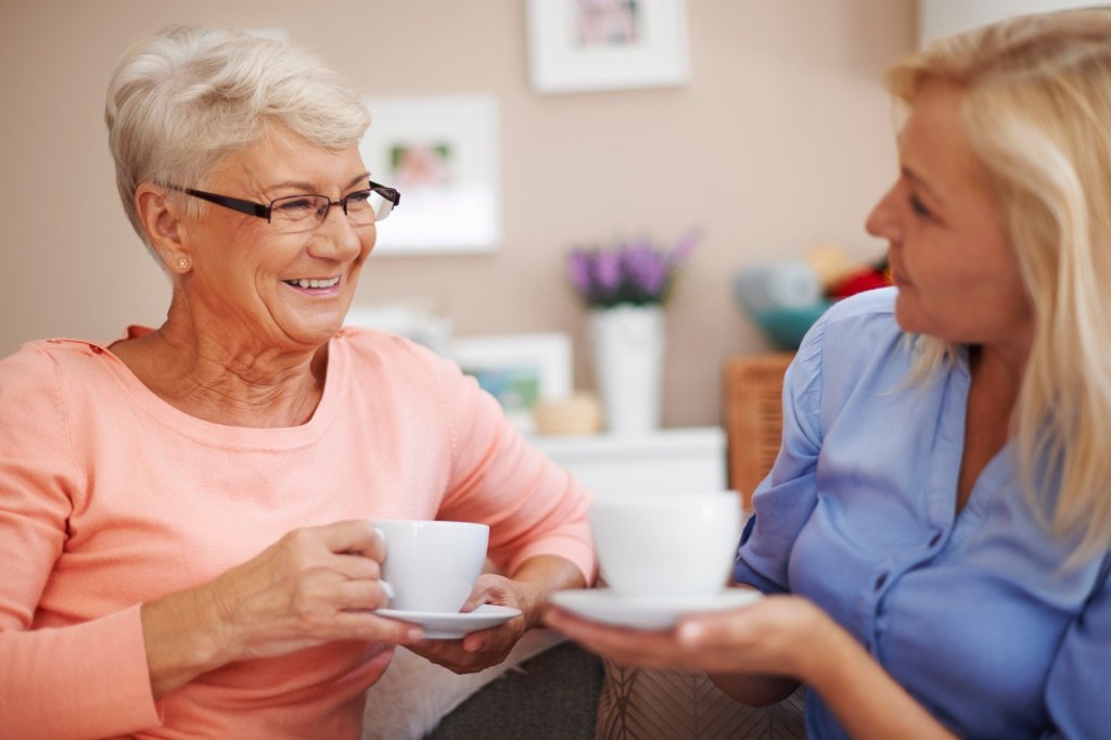 A caregiver enjoying some tea time with her mother