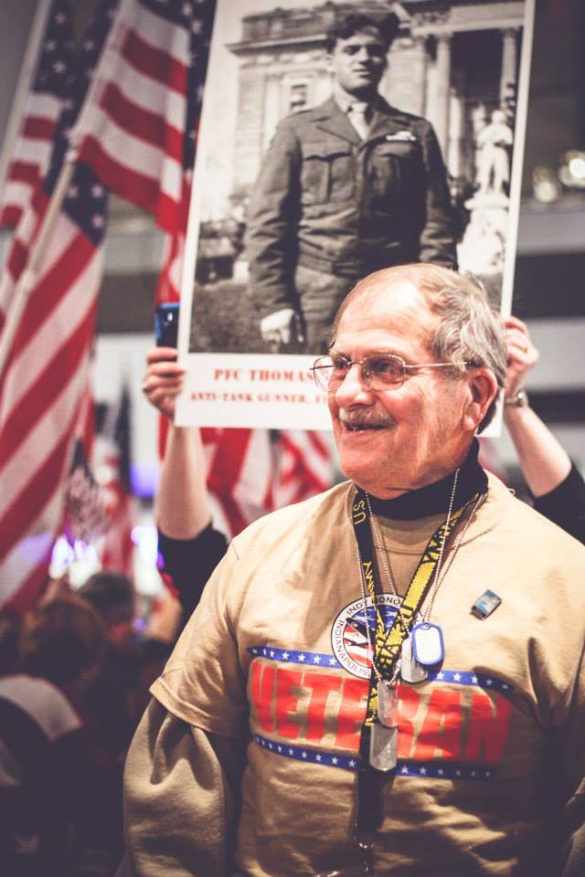 A veteran smiling in a large crowd