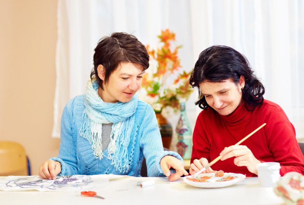 A caregiver painting with their loved one