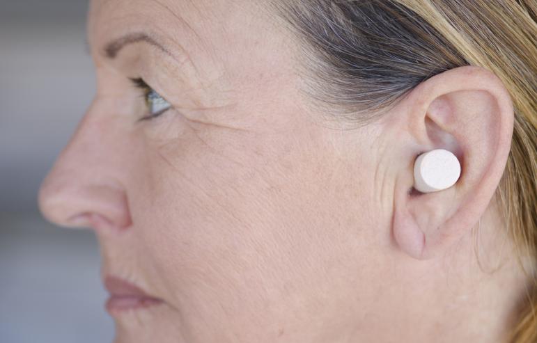 A lady wearing ear plugs