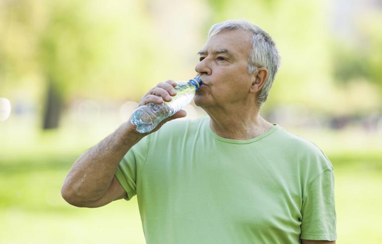 A caregiver takes a sip of water after completing an outdoor exercise
