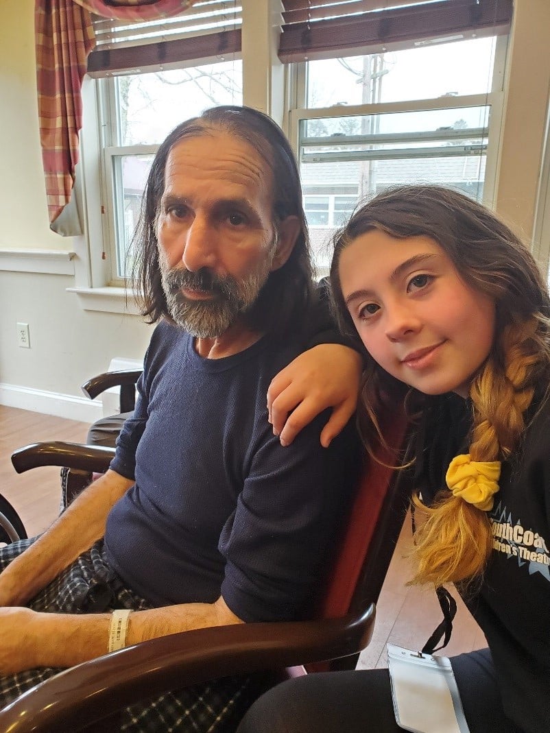 A caregiver daughter posing for a picture with her father