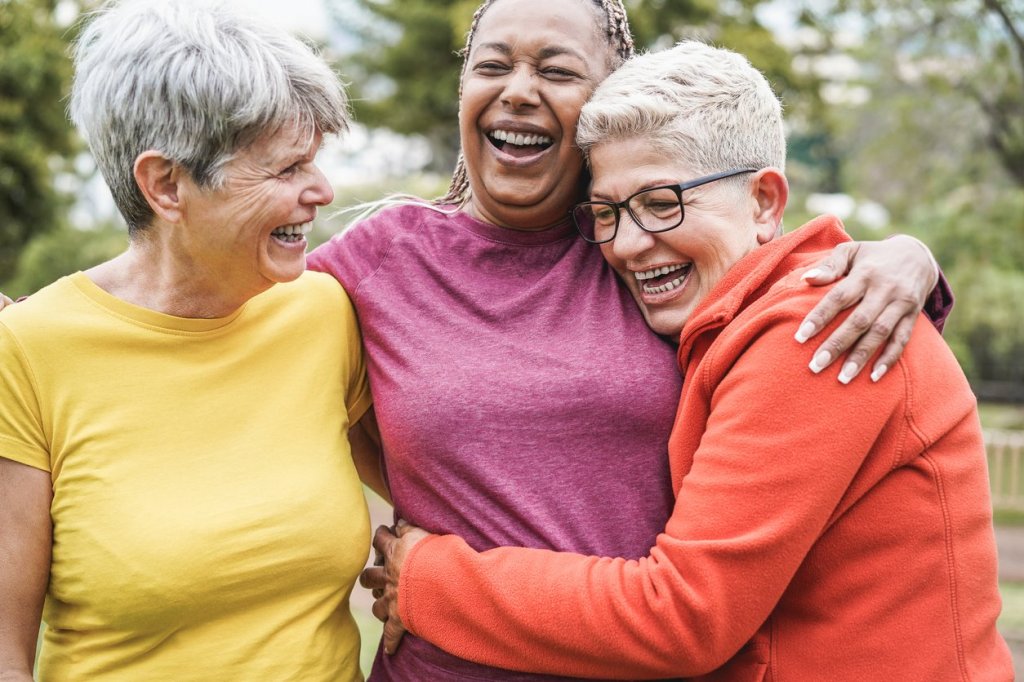 Three ladies hugging and smiling, radiating warmth and support in a shared journey of caregiving