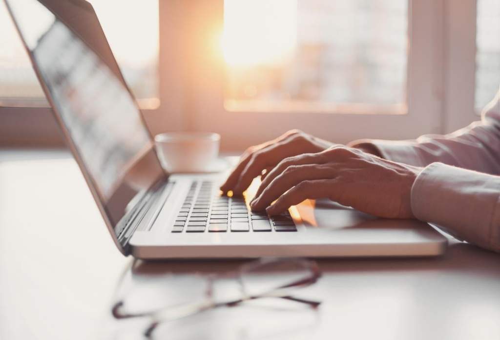 A caregiver typing on a laptop