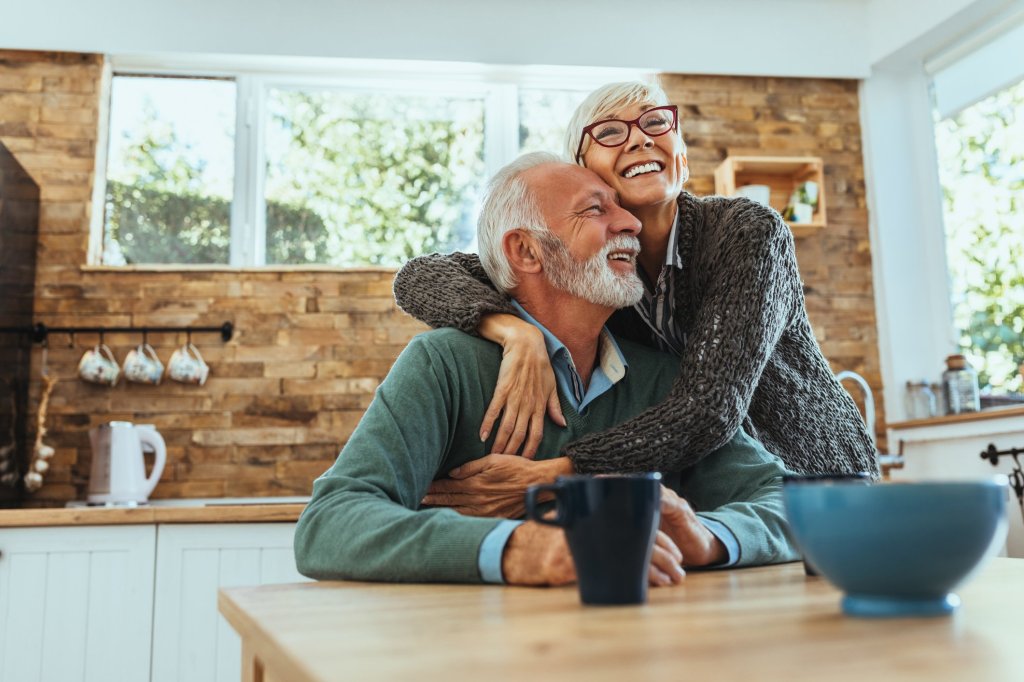 A happy older couple smiling and hugging, illustrating the joy and support found in caregiving relationships