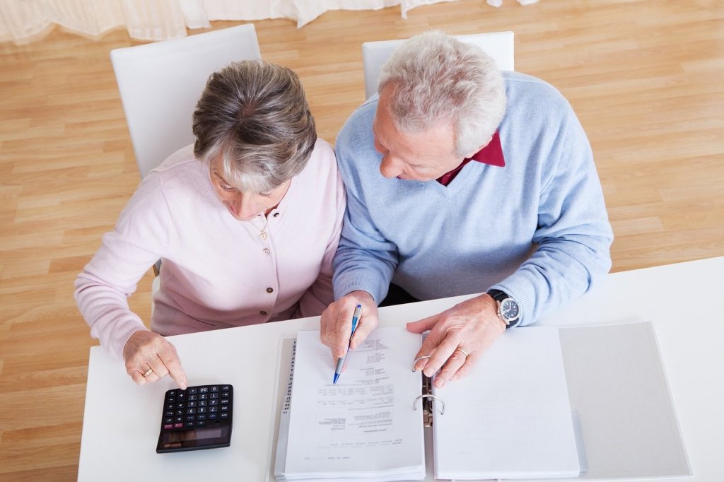 An elderly couple reviews finances for future caregiving needs