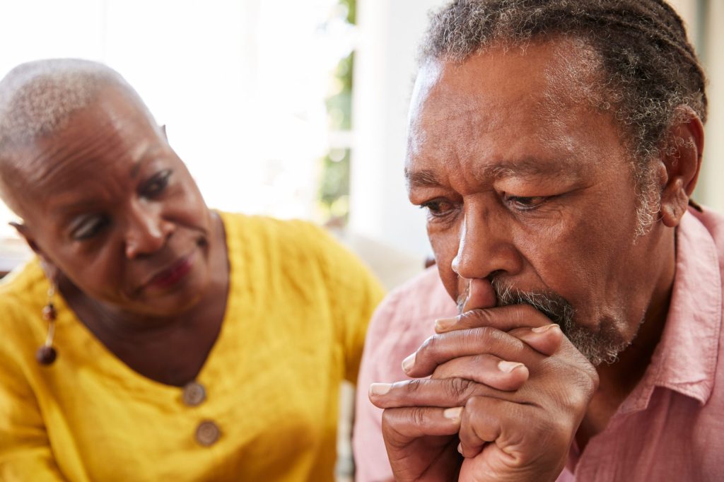 Elderly couple in a caregiving moment, expressing concern