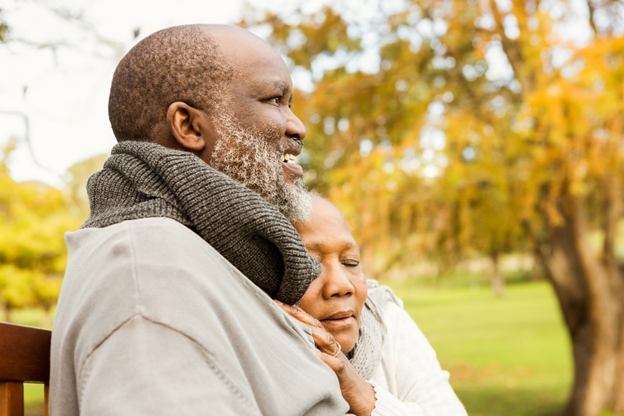 Caring couple at the park, demonstrating loving caregiving through a comforting cuddle