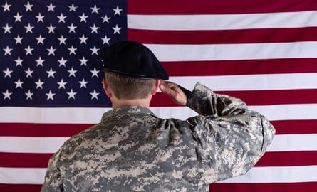 Veteran saluting the American flag, demonstrating respect and patriotism