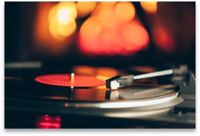 A record player playing a record in front of a fireplace