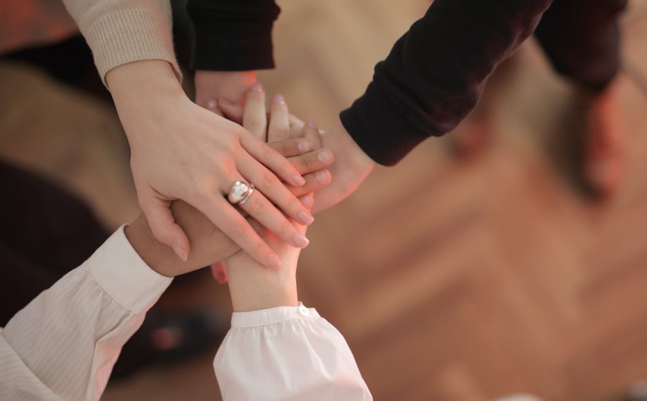 A group of caregivers putting their hands together