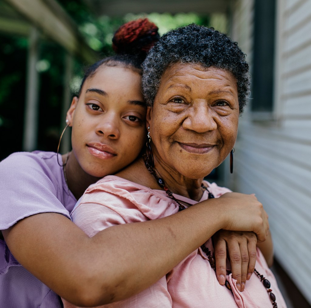 Portrait of black grandmother with teenager granddaughter both are looking into the camera. Members of a black middle class America family.