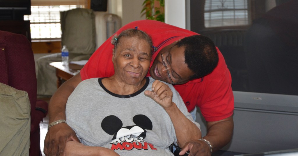 A caregiver son giving his mother a hug