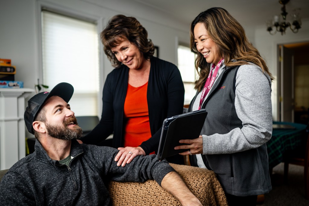 A caregiver with her loved one and their care coordinator